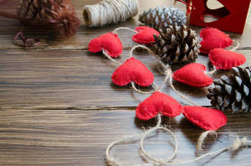 Christmas or New Year background. Making decoration for fir tree, felt heart garland and bobbins on wooden rustic table. Winter holidays concept. Copy space.