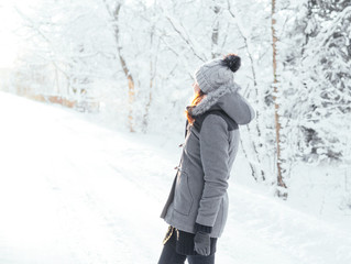 Fototapeta na wymiar Happy girl walking in a beautiful winter forest