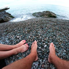 feet resting on a sculpture of mermaids