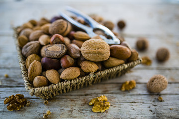Nuts in basket on a rustic wooden table.