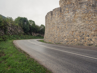 Fototapeta na wymiar Road near the old castle wall