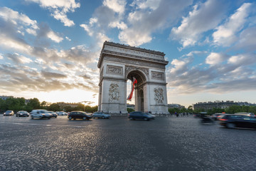 Fototapeta na wymiar Arc de Triomphe and blurred traffic at sunset