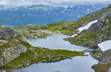 Tarn at the top of the mountains with summer snow at Stordalsnippa near Roeldal in Norway