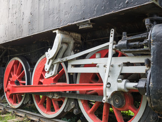 Old steam locomotive wheels and rods closeup