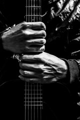 musician hands holding guitar, black and white filter for music background