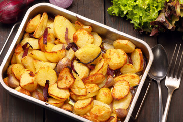 Baked potatoes in a roasting pan with garlic