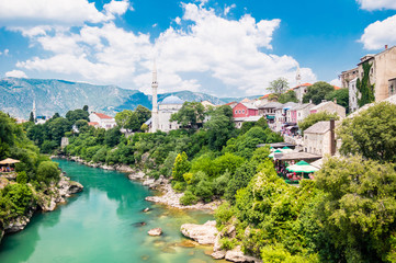 Fototapeta na wymiar Beautiful view on Mostar city with old bridge, mosque and ancient buildings on Neretva river in Bosnia and Herzegovina