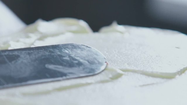 Confectionery spatula dub cream. Cooking cake with cream. Cake with cream. Chocolate sponge cake with cream. The food for the holiday. for the holiday cake. Preparation of cake in a candy store.