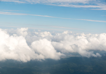 Obraz premium Cloudscape view with mountain above white clouds and blue sky from airplane