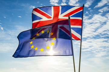 European Union and British Union Jack flag flying in front of bright blue sky in a backlit statement of the Brexit EU referendum © lazyllama