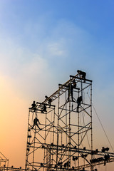 Silhouette of workmen at Twilight / Silhouette of workmen in mounting the outdoor concert stage, Twilight scene