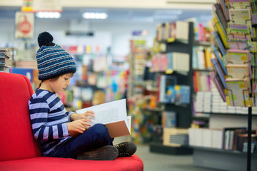 Adorable little child, boy, sitting in a book store © Tomsickova