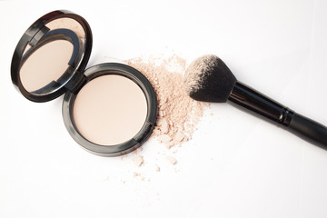 black cosmetic brush and puff-box of powder on a white background 