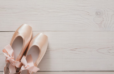 Pink ballet pointe shoes on white wood background