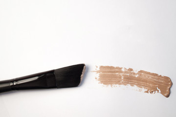 cosmetic brush and stroke of foundation on a white background 