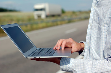 A man with a computer on the road
