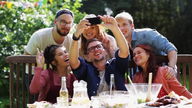 friends taking selfie at party in summer garden