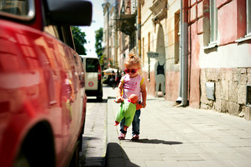 Fashion little girl walking with her doll