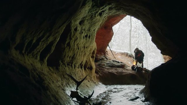 Prehistoric caveman goes to his cave