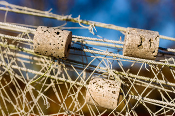 Small cork floats on fishnets hung out to dry. Shallow focus on float and blurred background.