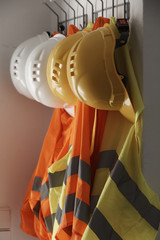 Hardhats and safety jackets on hanger