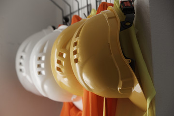 Yellow and white safety hardhats on hanger