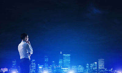 Businessman viewing night glowing city