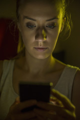 Fototapeta na wymiar Unhappy Teenage Girl Sending Text Message, at night