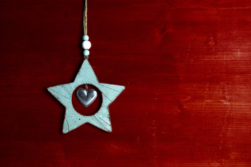 minzfarbener Weihnachtsstern aus Holz vor roter Holzwand