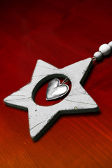 weisser Weihnachtsstern aus Holz vor roter Holzwand