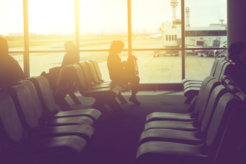 women sit on seat in a lobby airport waiting for flight, soft vi