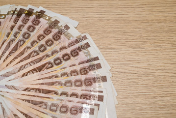 Thousand bath Thai money on wooden table with copy space