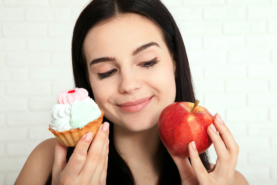 Woman with apple closeup face. Beautiful women exists to clean skin on the face that chooses to eat an apple or cake. Asian woman.