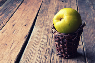 Green apple in small wicker basket