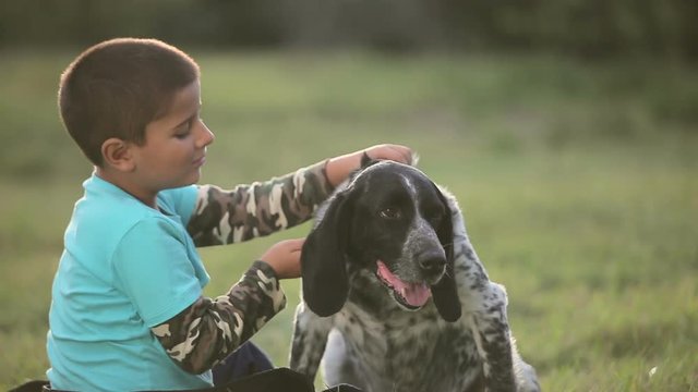 boy ans dog sitting on the lawn