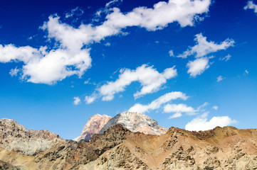 mountain peaks against the blue sky with clouds