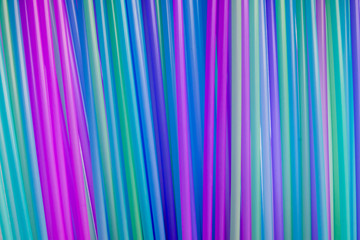 Many different colored plastic drinking straws. Vertically arranged. Abstract background