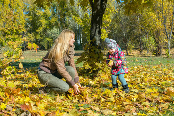 Young mother is playing with little daughter, throw each other f