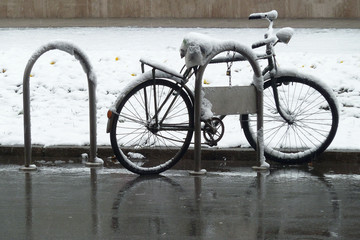 Fototapeta na wymiar Bike covered with snow on the street