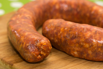 Fototapeta premium Closeup macro domestic red sausage on the wooden board