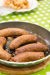 Fried homemade sausages in the frying pan