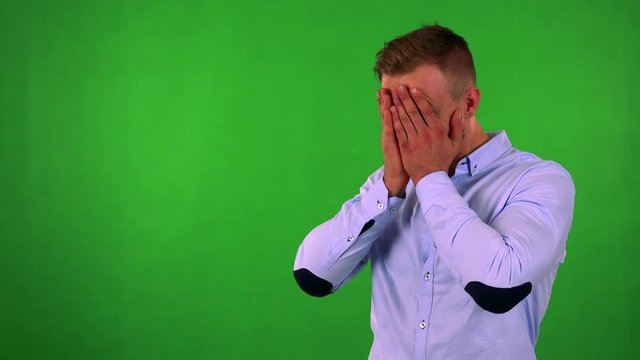 young handsome business man cries - green screen - studio