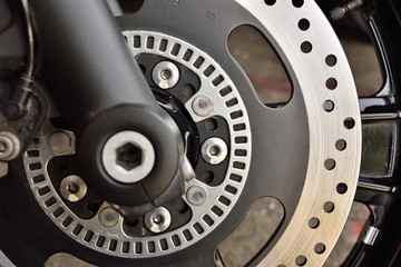 The front wheel of a motorcycle. Close up brakes and spokes