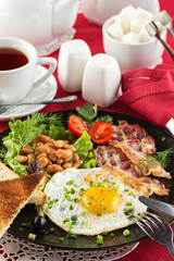 English breakfast with bacon, fried egg and beans