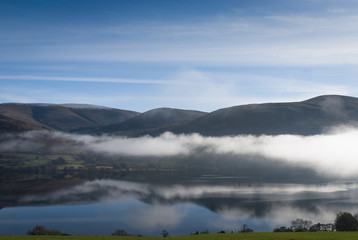 A landscape image of mist rising above Loch Tay in the Scottish Highlands.