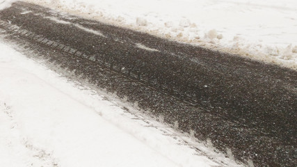 Winter slippery road background, asphalt pavement under fresh snow layer