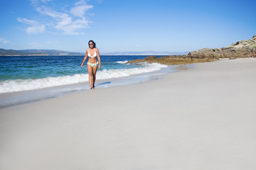 Fototapeta na wymiar young woman walking in the beach