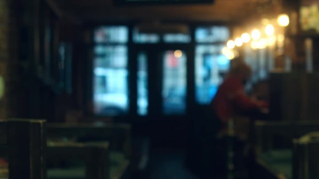 Defocused background - a people sit in a modern cafe. 4K UHD