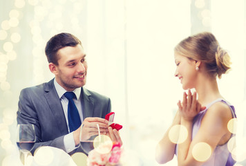 Obraz na płótnie Canvas man proposing to his girlfriend at restaurant
