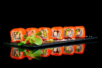 california rolls on black background with reflection